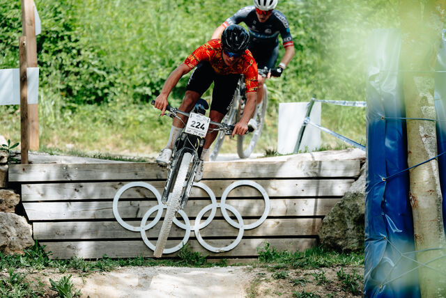 Pilote VTT franchissant les anneaux olympiques
